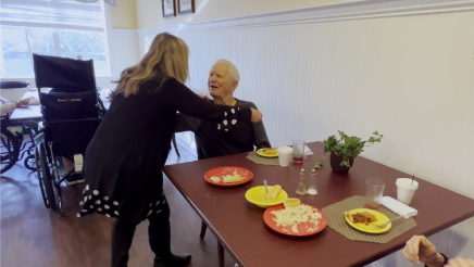 Caregiver waiting on senior at a table