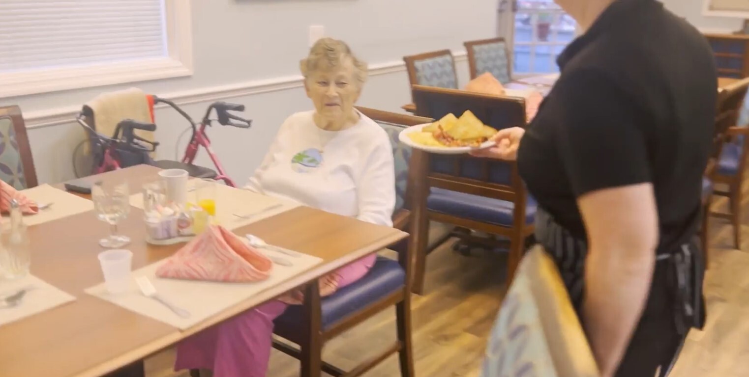 Senior being served food